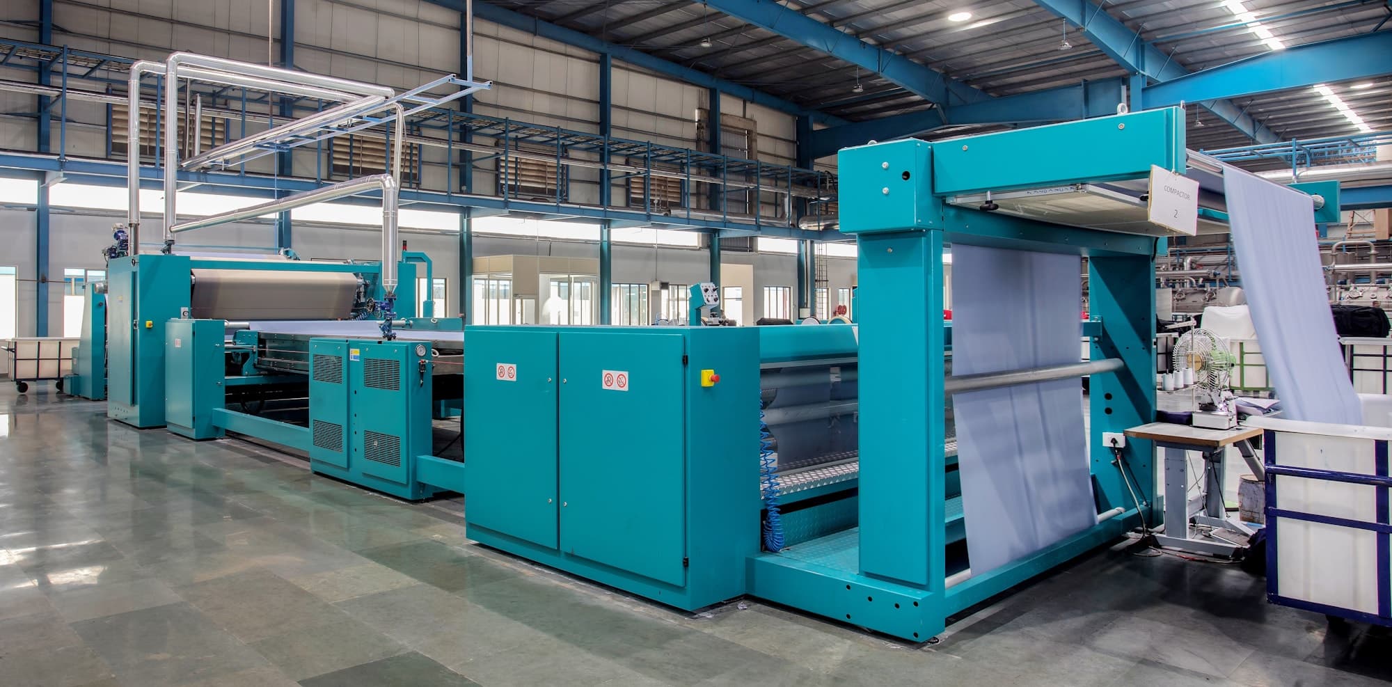 Knitted fabric running through a compactor in a modern finishing plant